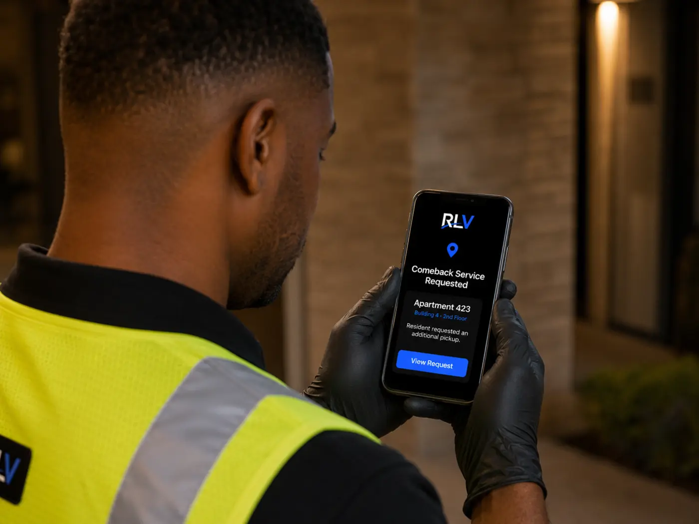 Relaxed Living Valet worker receiving an apartment comeback service request on a phone